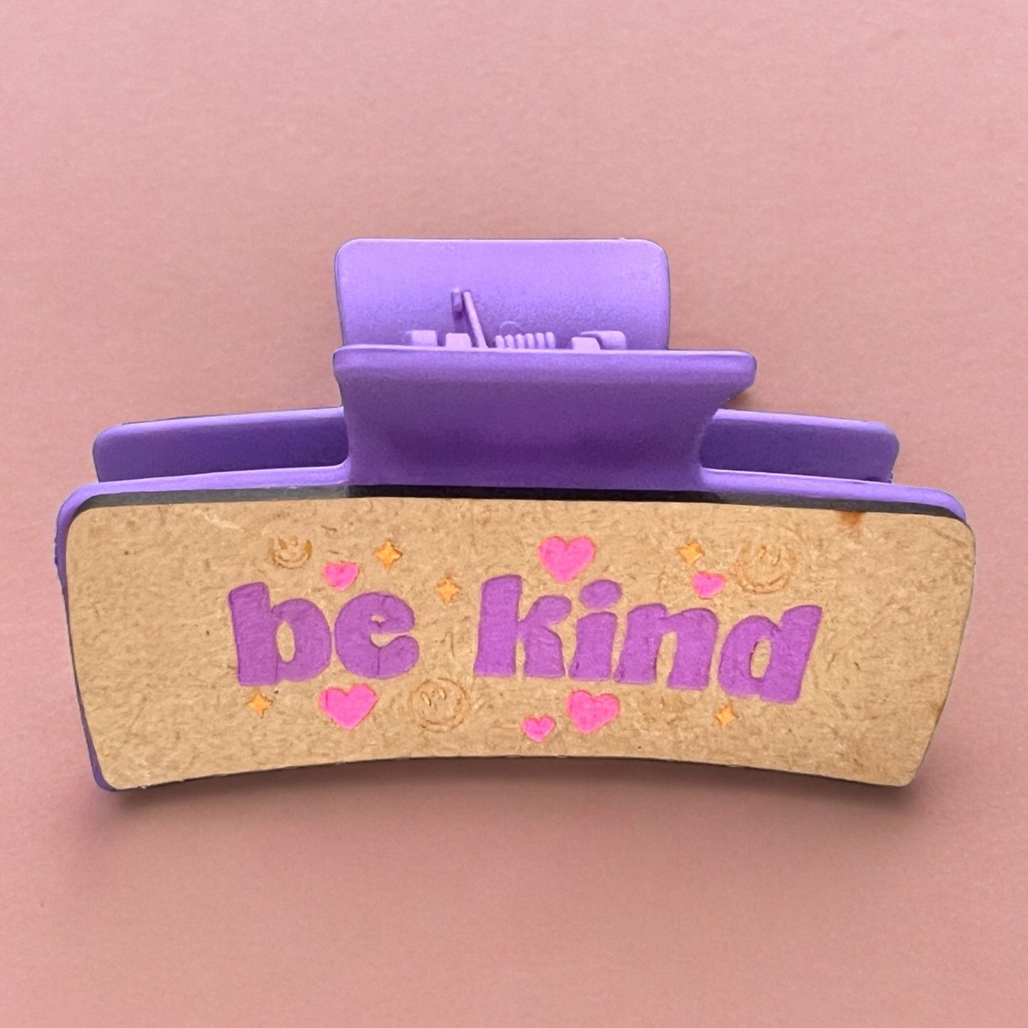 a claw clip with the words be kind and smiley smile faces and stars and hearts