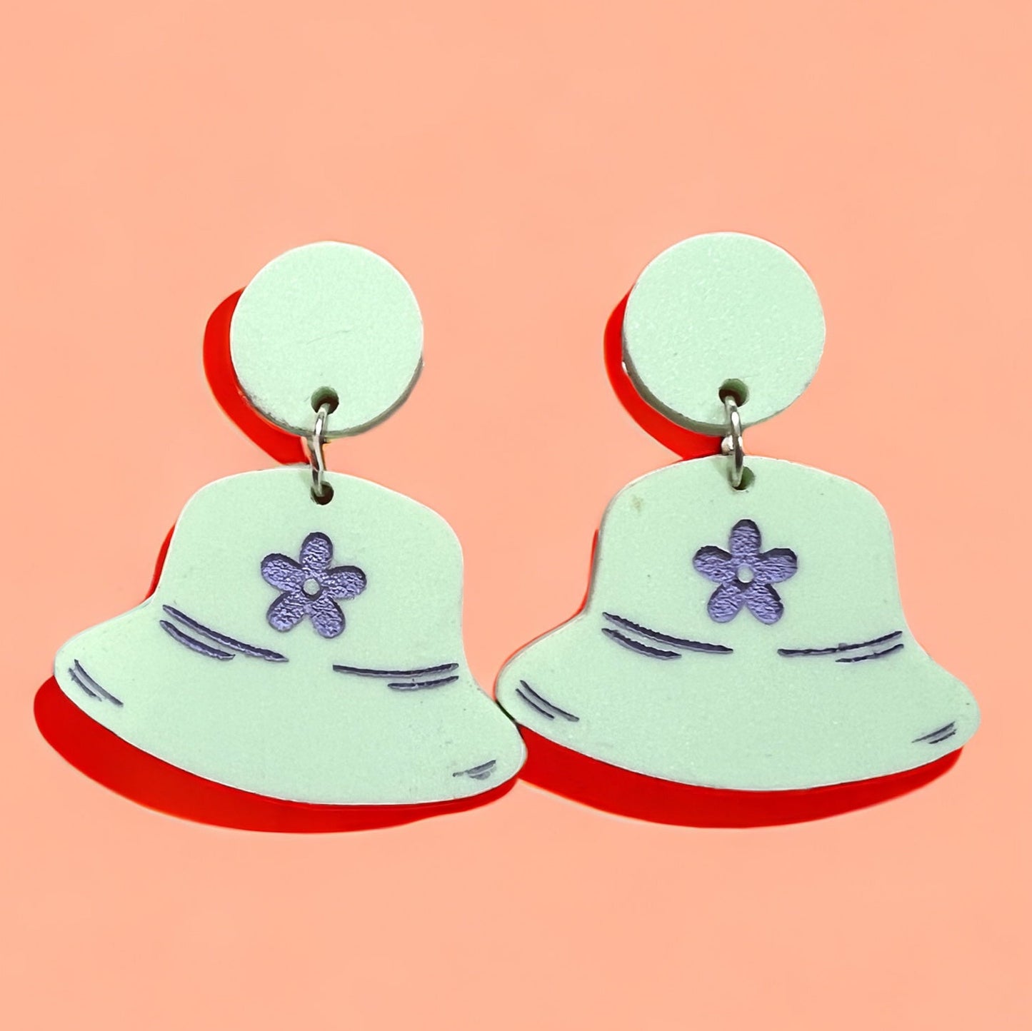 green teal acrylic earrings in the shape of a retro bucket hat from the 90's nineties with lavender accents and a daisy, with silver hardware. a perfect gift for the vintage loving woman.