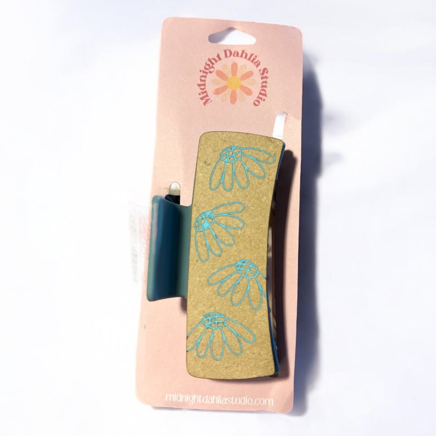 a hair claw clip with chamomile flowers in light blue