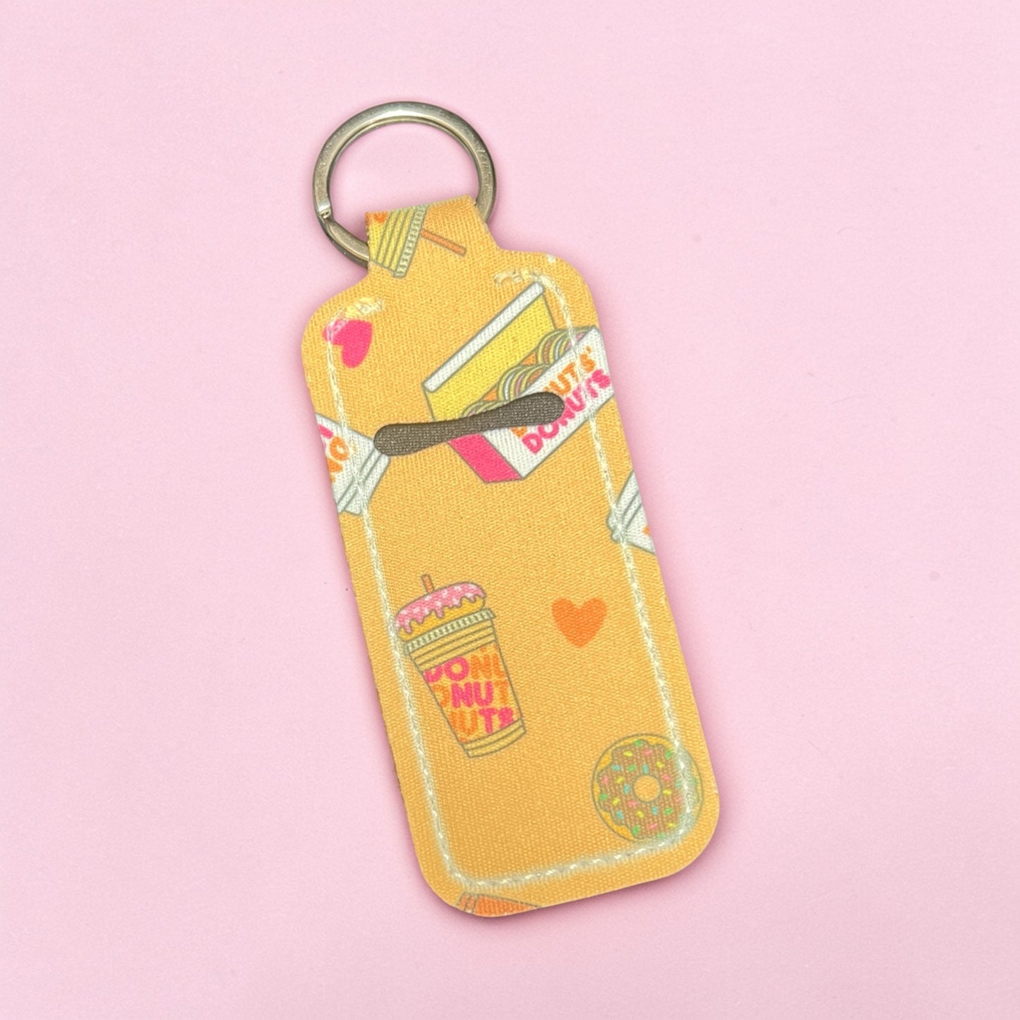 Yellow keychain with donut-themed design on a pink background