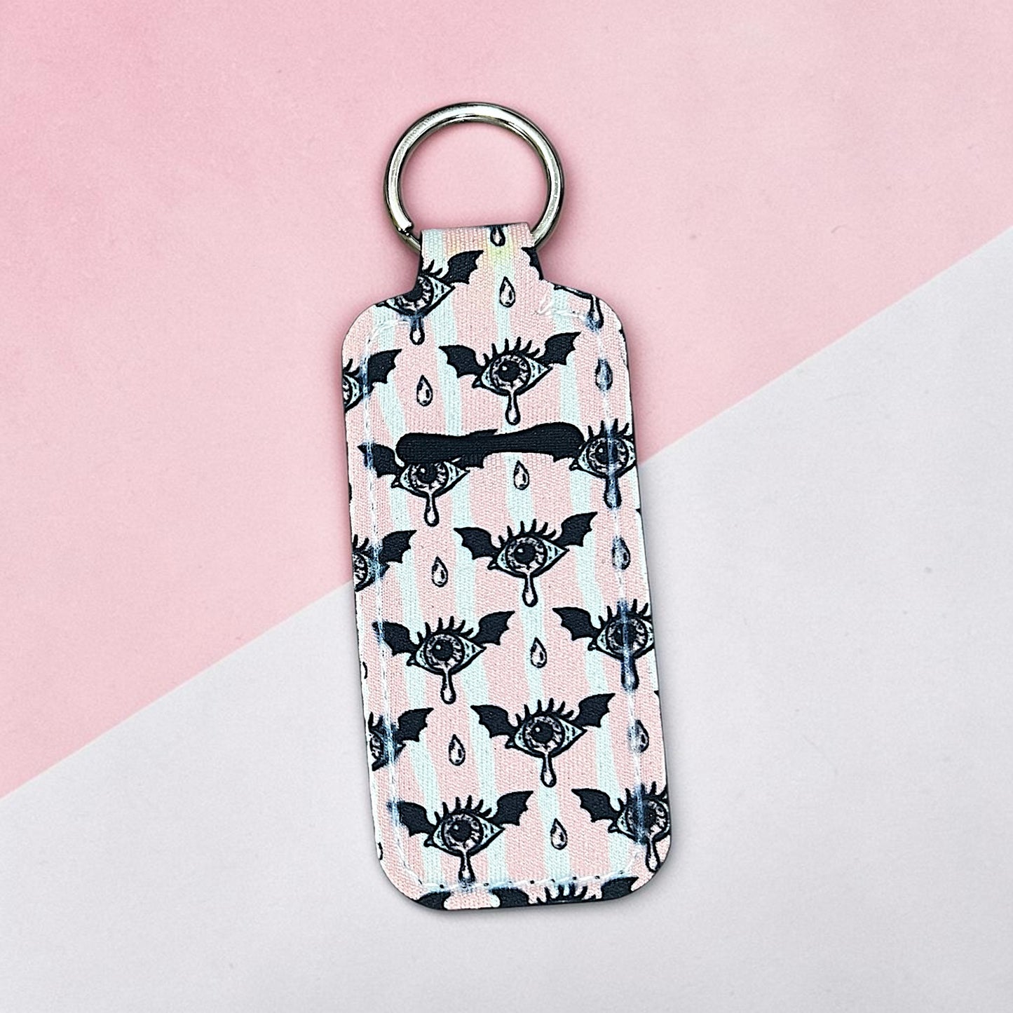 Keychain with black and white pattern on a pink and gray background
