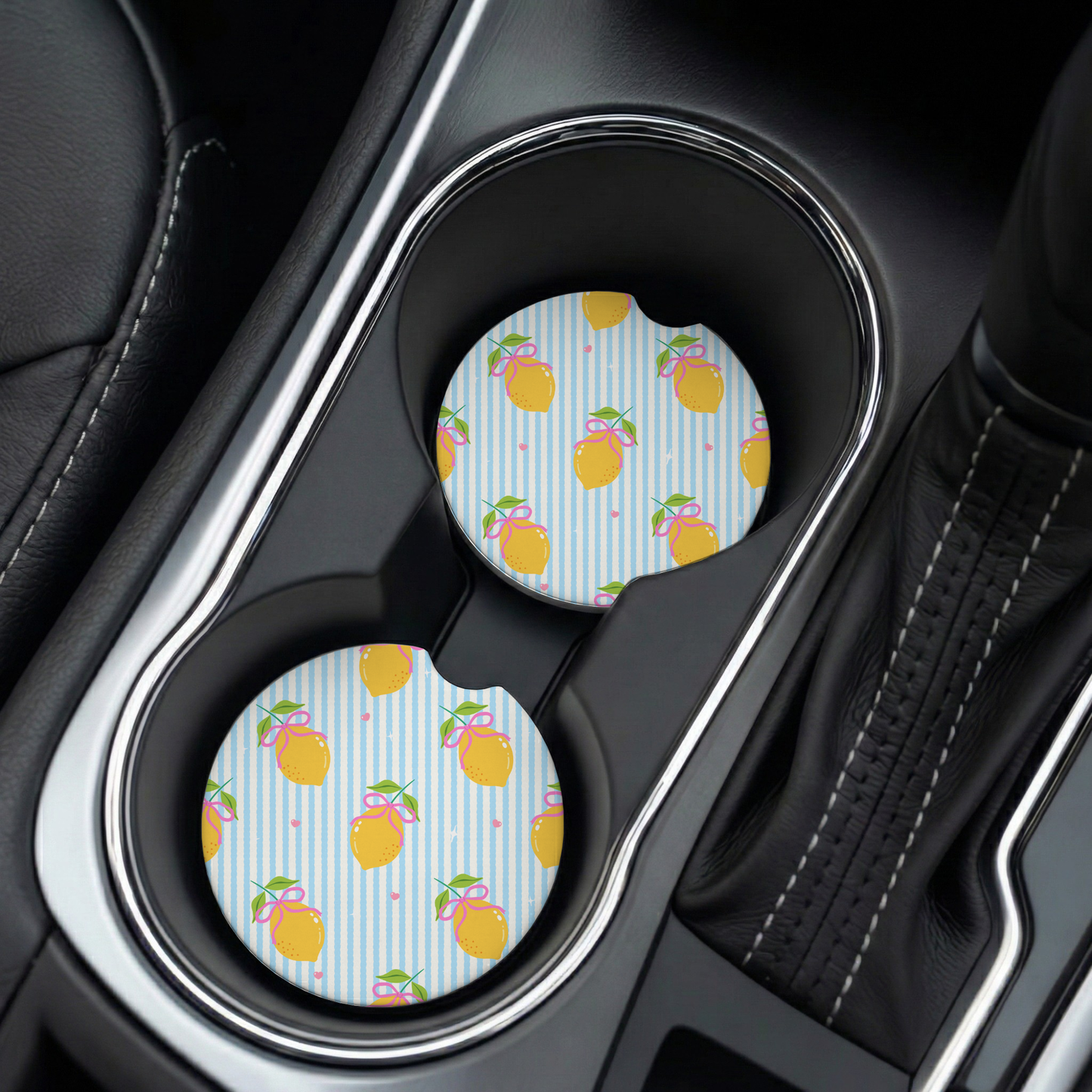 Car cup holder with a decorative car coaster featuring text and lemon prints.