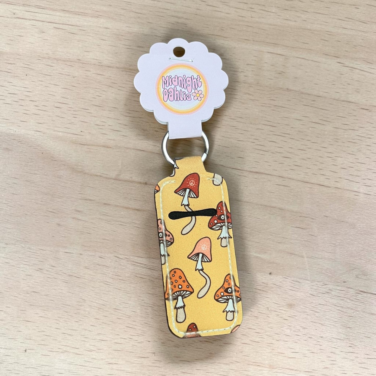 lip balm keychain with mushroom design on a wooden surface