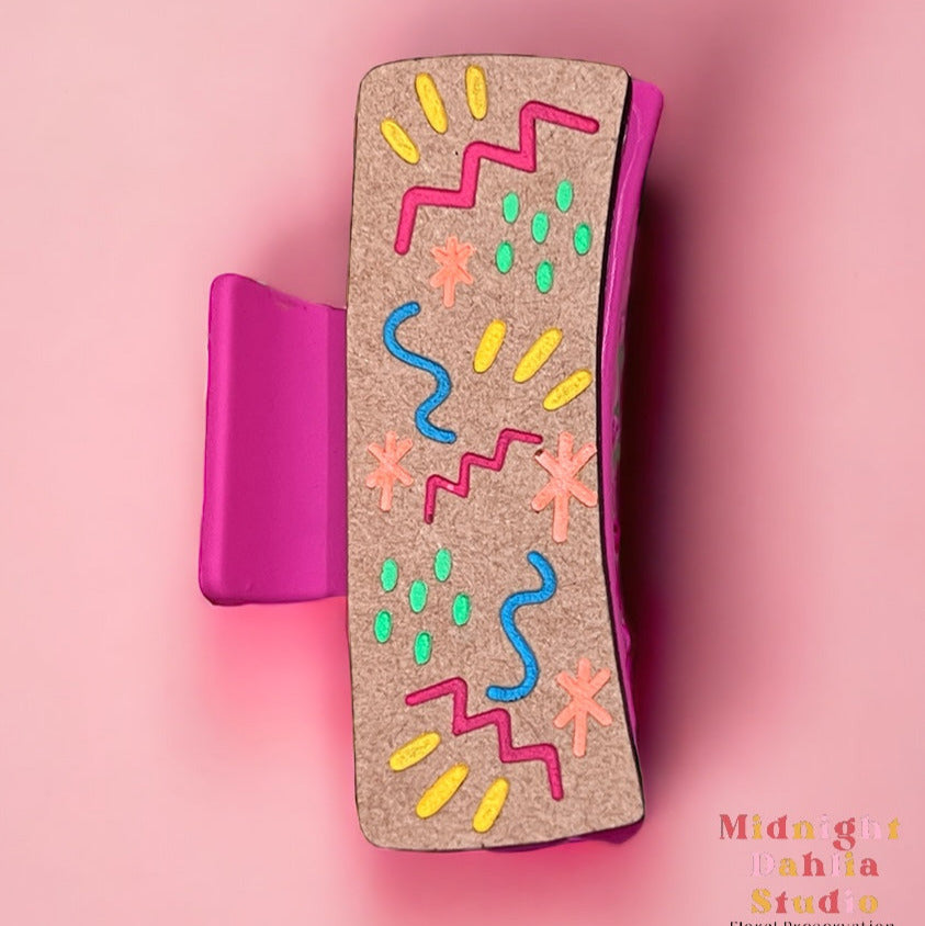 a claw hair clip with squiggles zigzags dots and stars in many colors