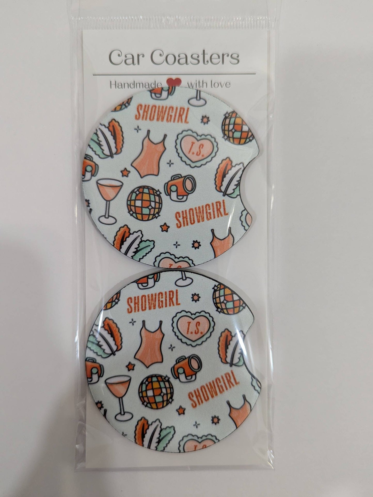 Two car coasters with 'Showgirl' design in packaging on a white background