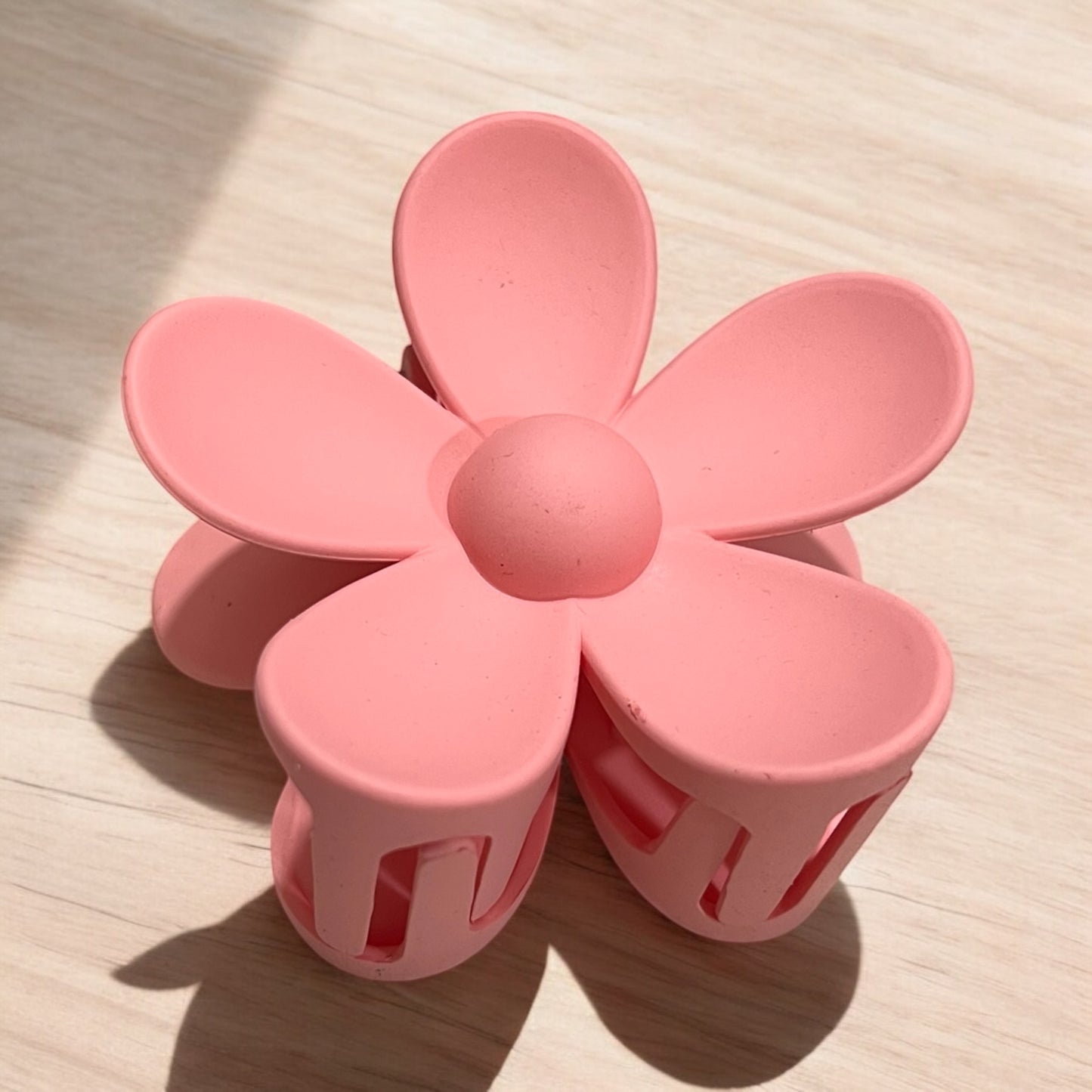 a daisy shaped plastic claw hair clip in pink