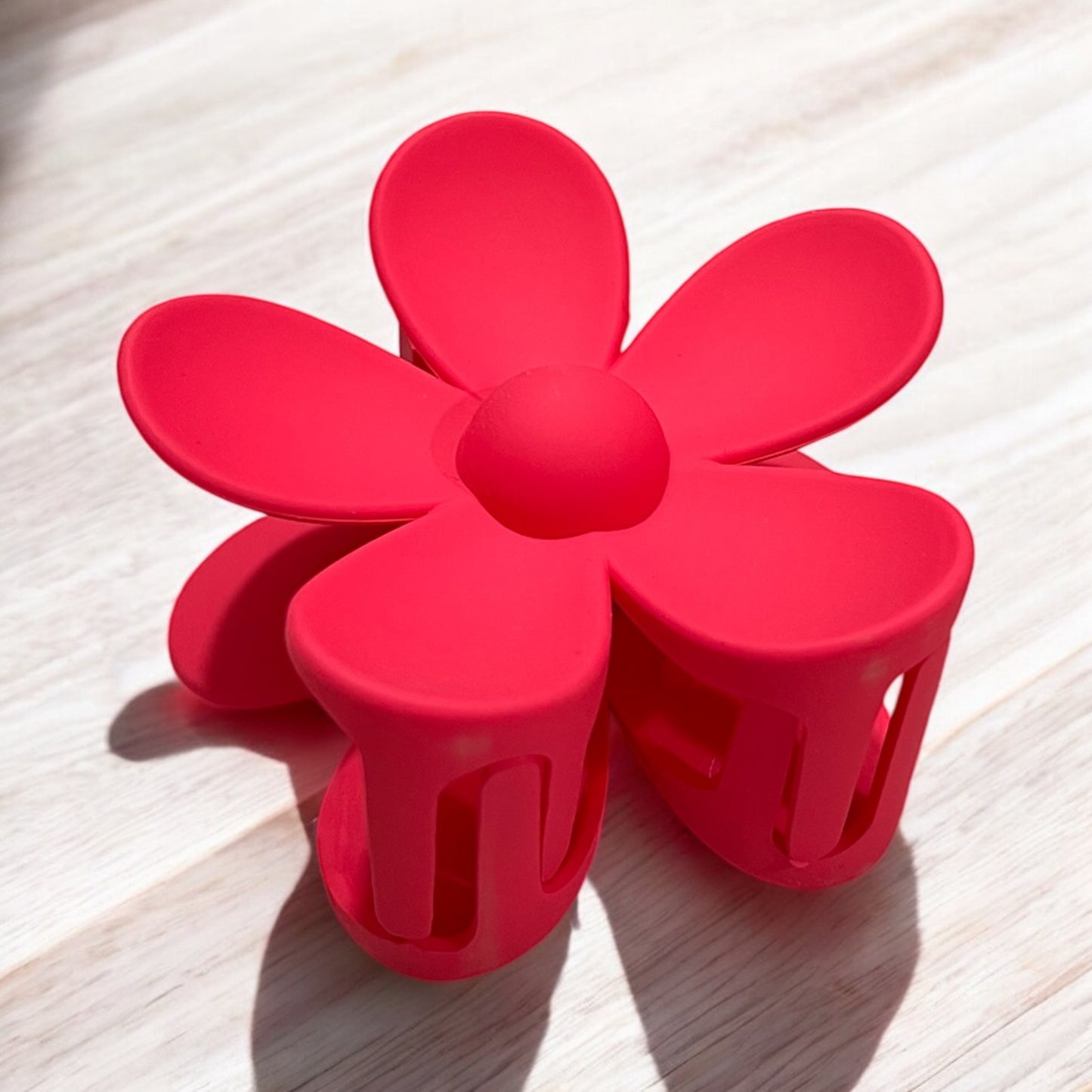 a daisy shaped plastic claw hair clip in red