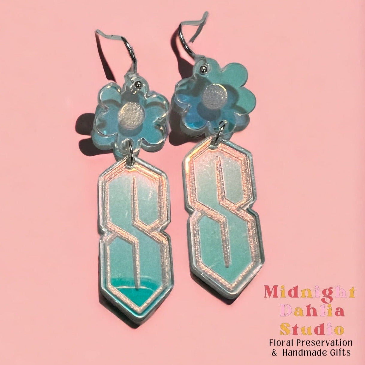 A pair of iridescent acrylic dangle earrings in the shape of a retro 90's nineties S with a daisy top. A cute gift for a woman especially for a nineties baby.