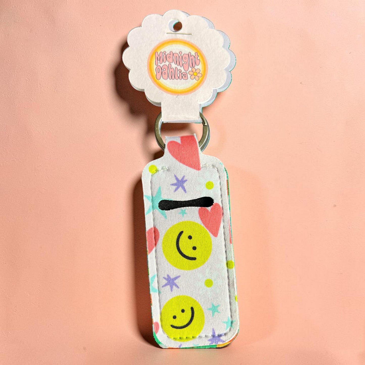 Keychain with smiley face design on a pink background