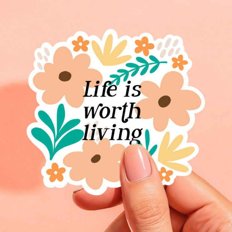 a white background sticker that reads life is worth living, surrounded by flowers