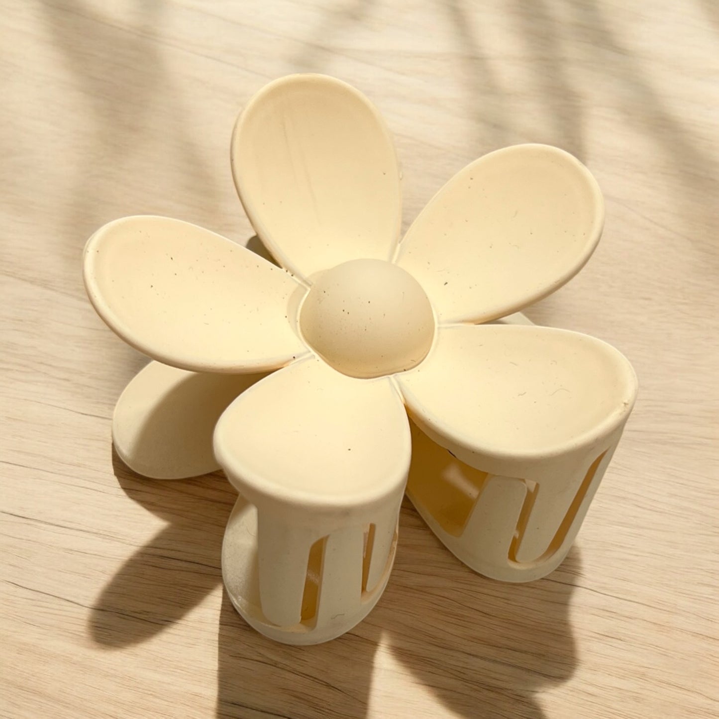 a daisy shaped plastic claw hair clip in yellow
