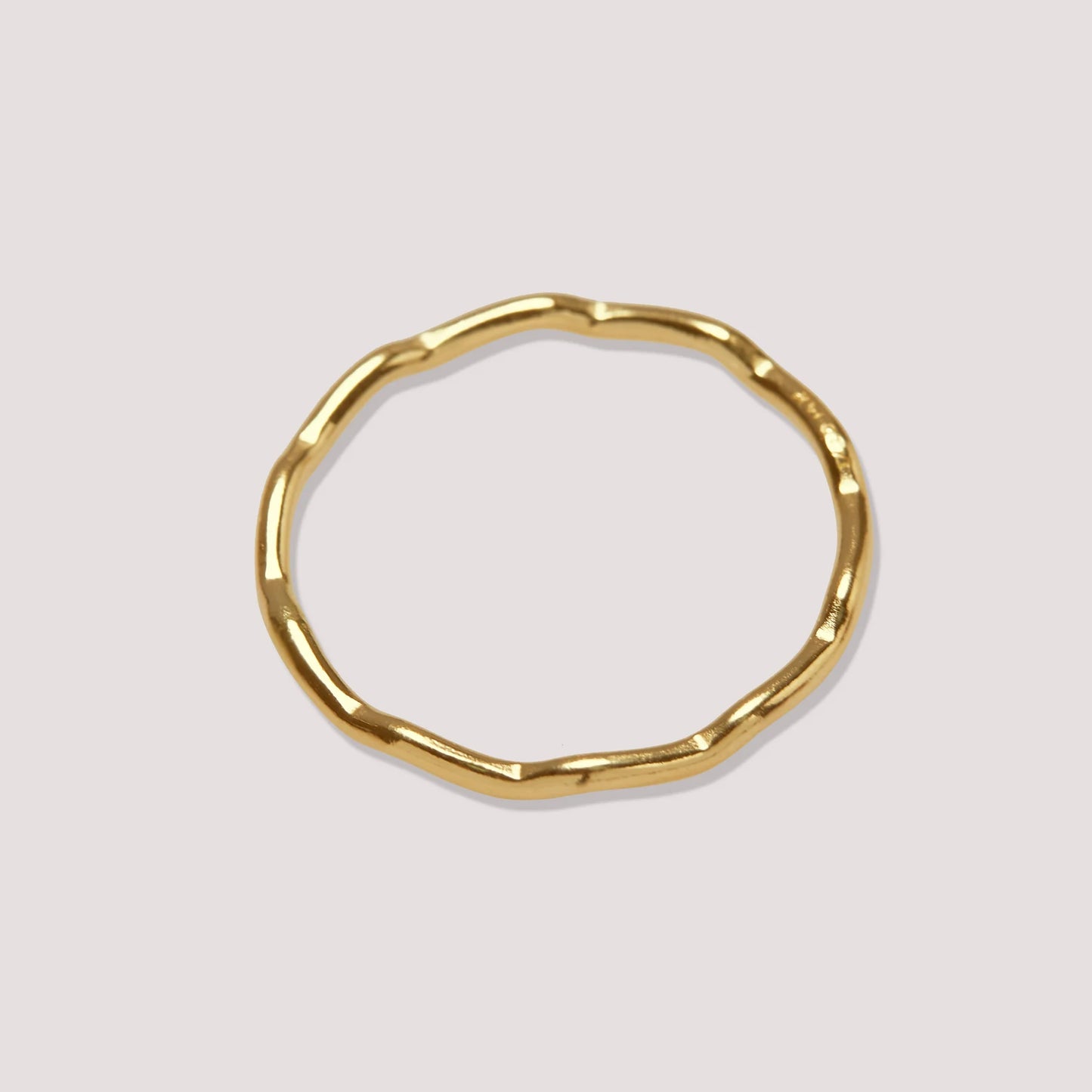 Gold ring with a unique design on a light gray background