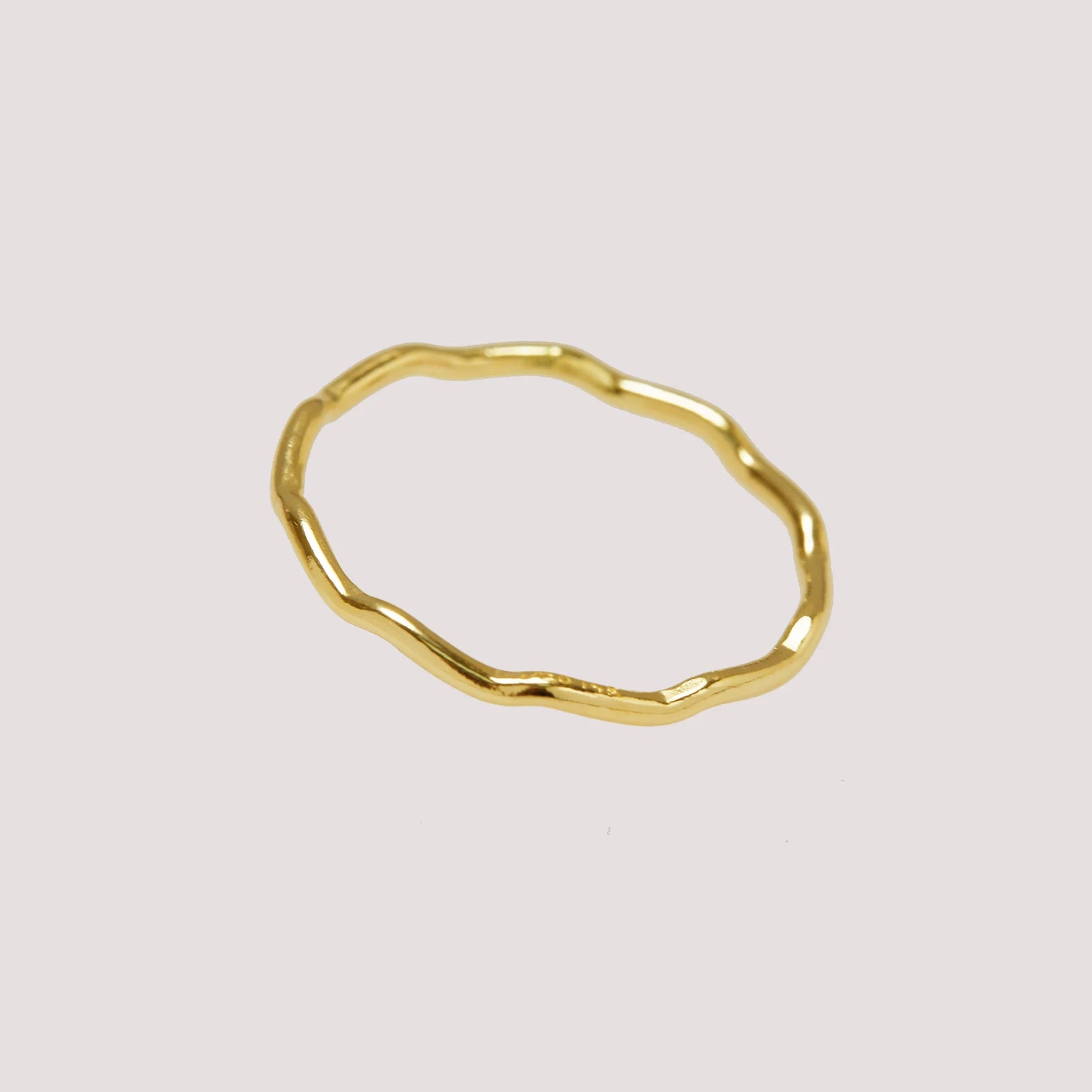 Gold ring with a textured surface on a light gray background