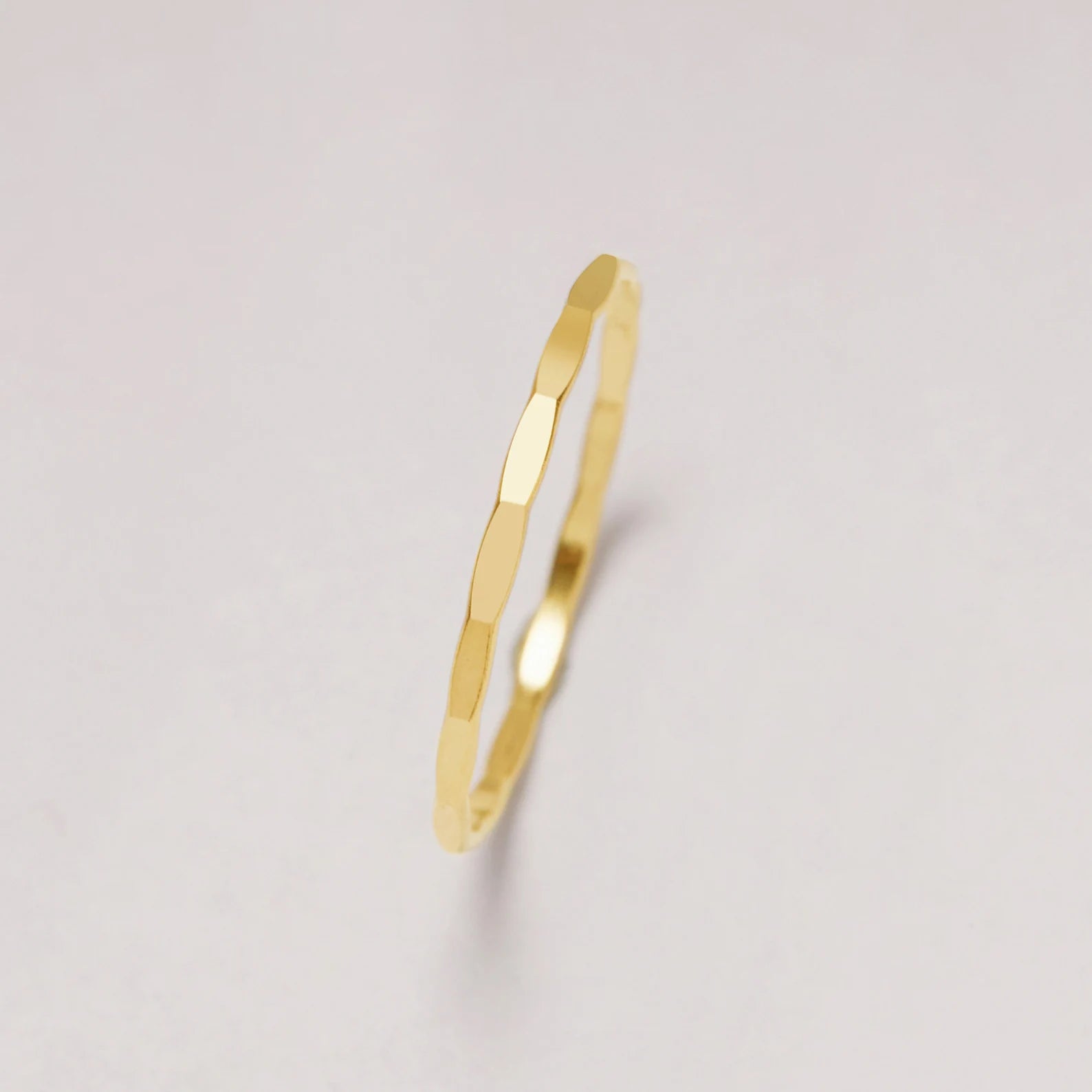 Gold ring on a light gray background