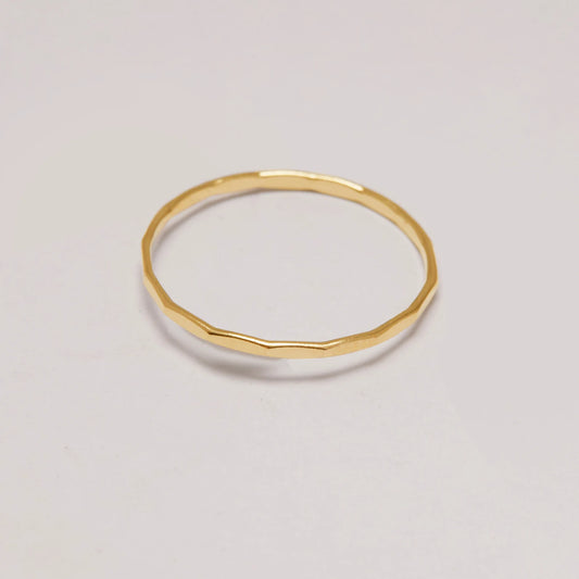 Gold ring on a light gray background