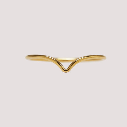 Gold ring with a wavy design on a light gray background