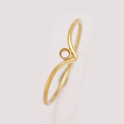 Gold ring with a unique design on a light gray background