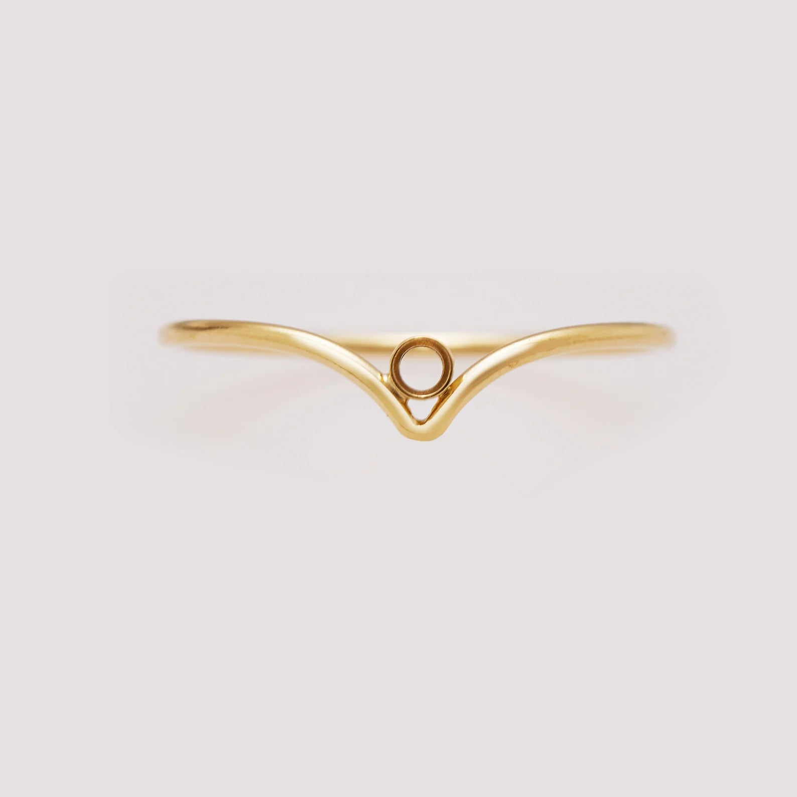 Gold ring with a unique design on a light gray background