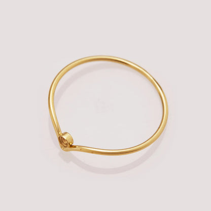 Gold bracelet on a light gray background