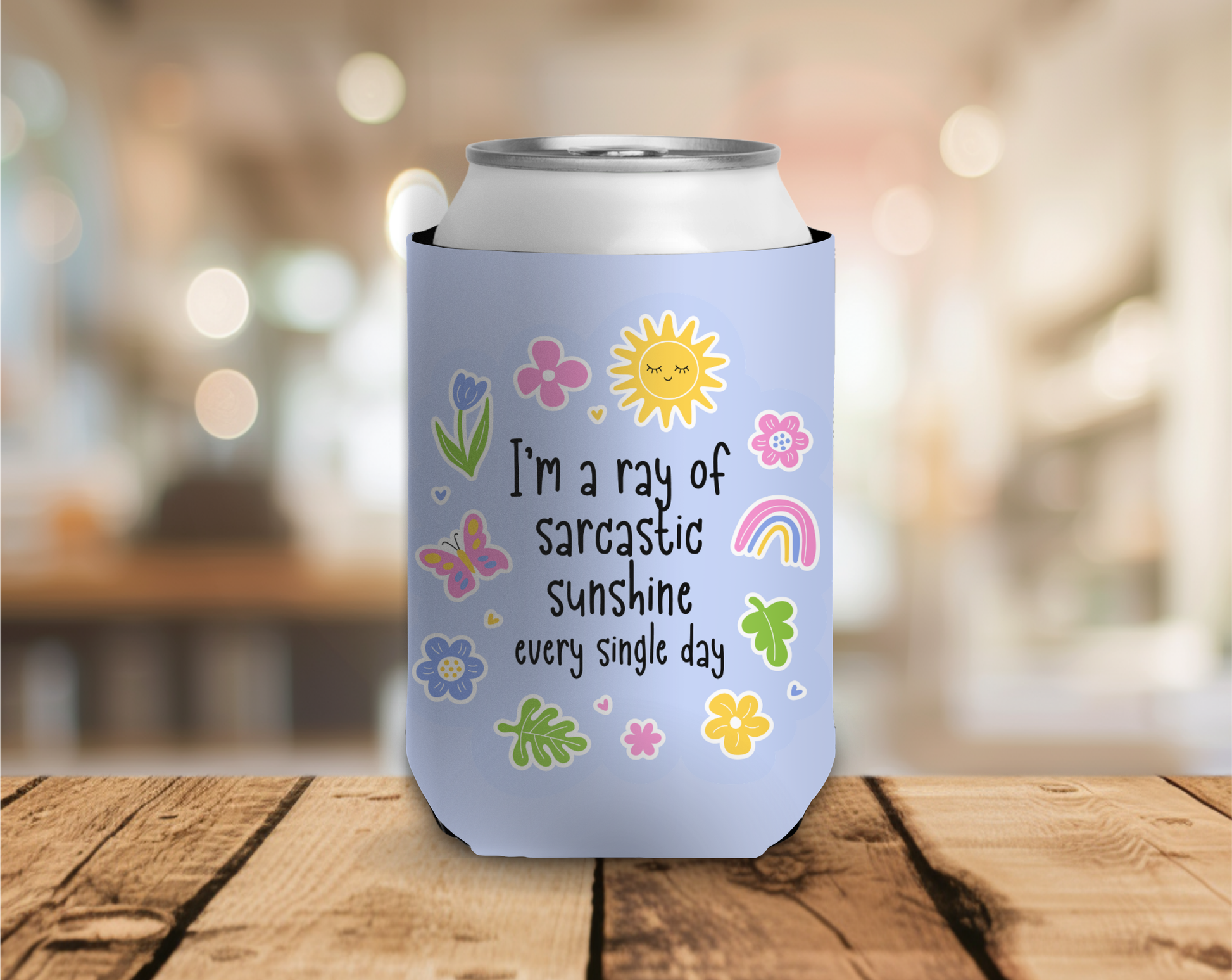 Can cooler with colorful design and text on a wooden surface