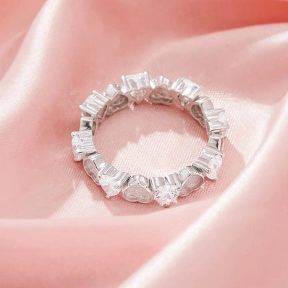 Silver ring with baguette-cut diamonds on a pink satin background