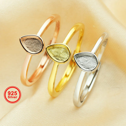 Three silver rings with teardrop-shaped stones on a beige background, featuring '925 Silver' label.