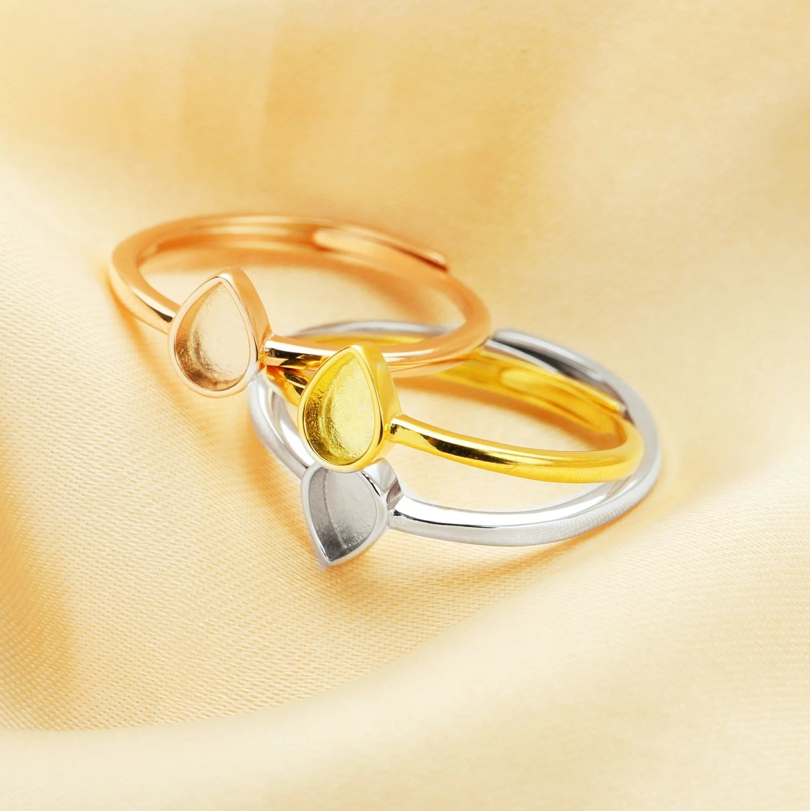 Two gold rings with a yellow gemstone on a gold background