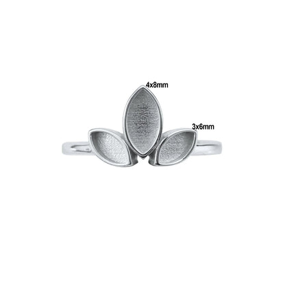 Silver ring with leaf-shaped stones of different sizes on a white background