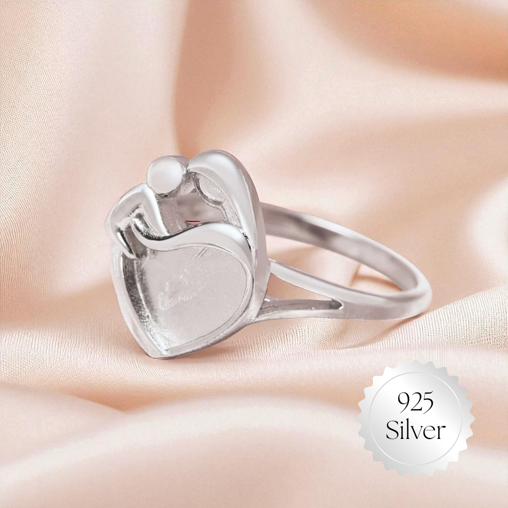 Silver heart-shaped ring on a soft fabric background with '925 Silver' label.