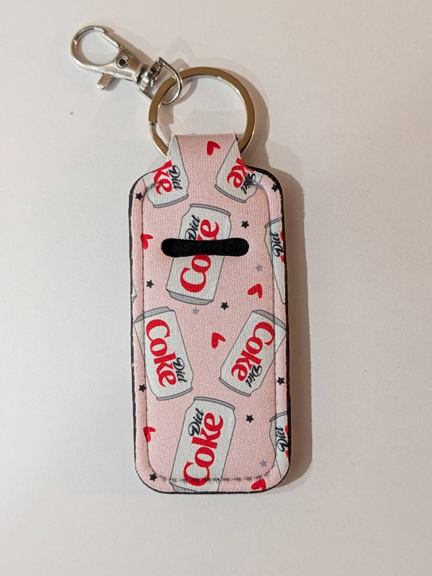 Keychain with Coca-Cola logo pattern on a light pink background