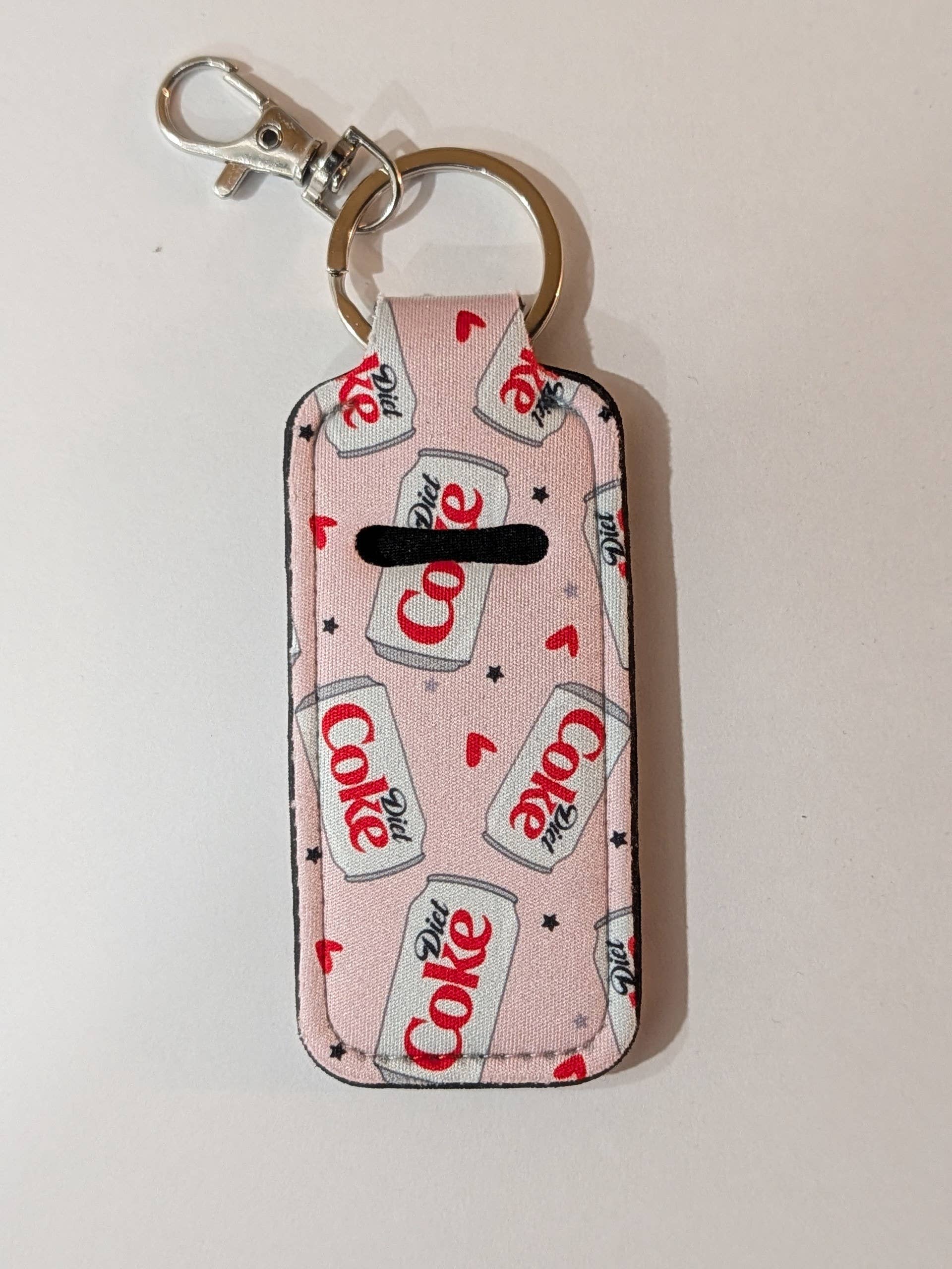 Keychain with Coca-Cola logo pattern on a light pink background