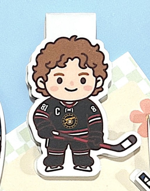 Sticker of a hockey player in a black jersey with a logo on a light blue background.