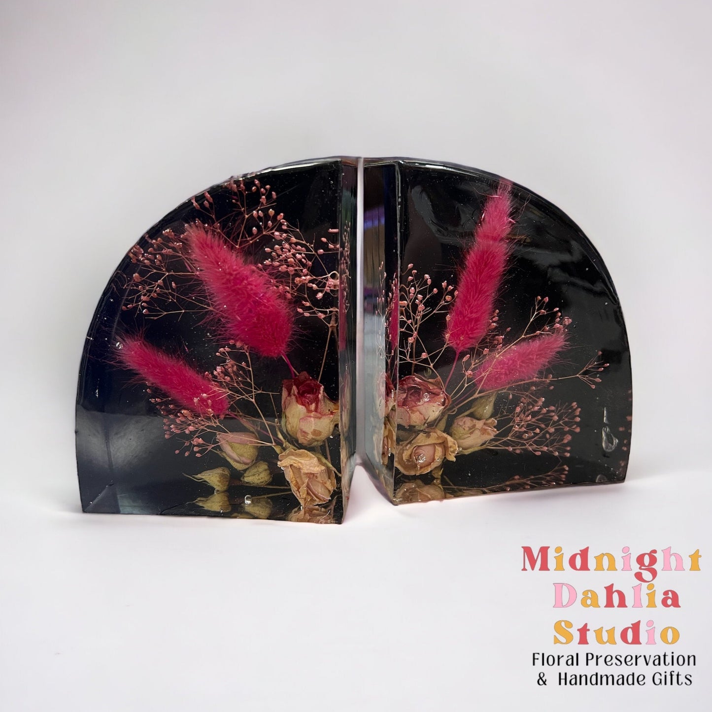 Custom resin bookend set made with white flowers included mini spray roses , pink bunny tail , and pink babys breath.  The back of the bookends are black.  A flower preservation option that is useful home decor forever.