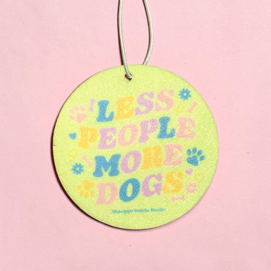 Round green tag with colorful text 'LESS PEOPLE MORE DOGS' on a pink background