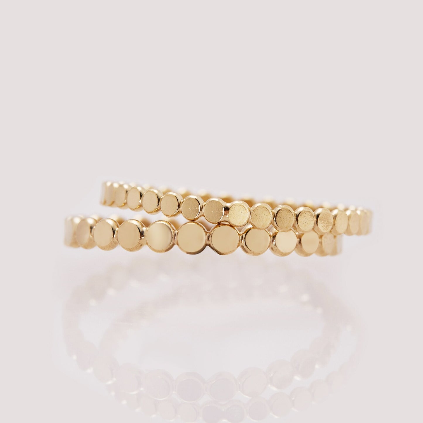 Two gold rings with a textured design on a light background