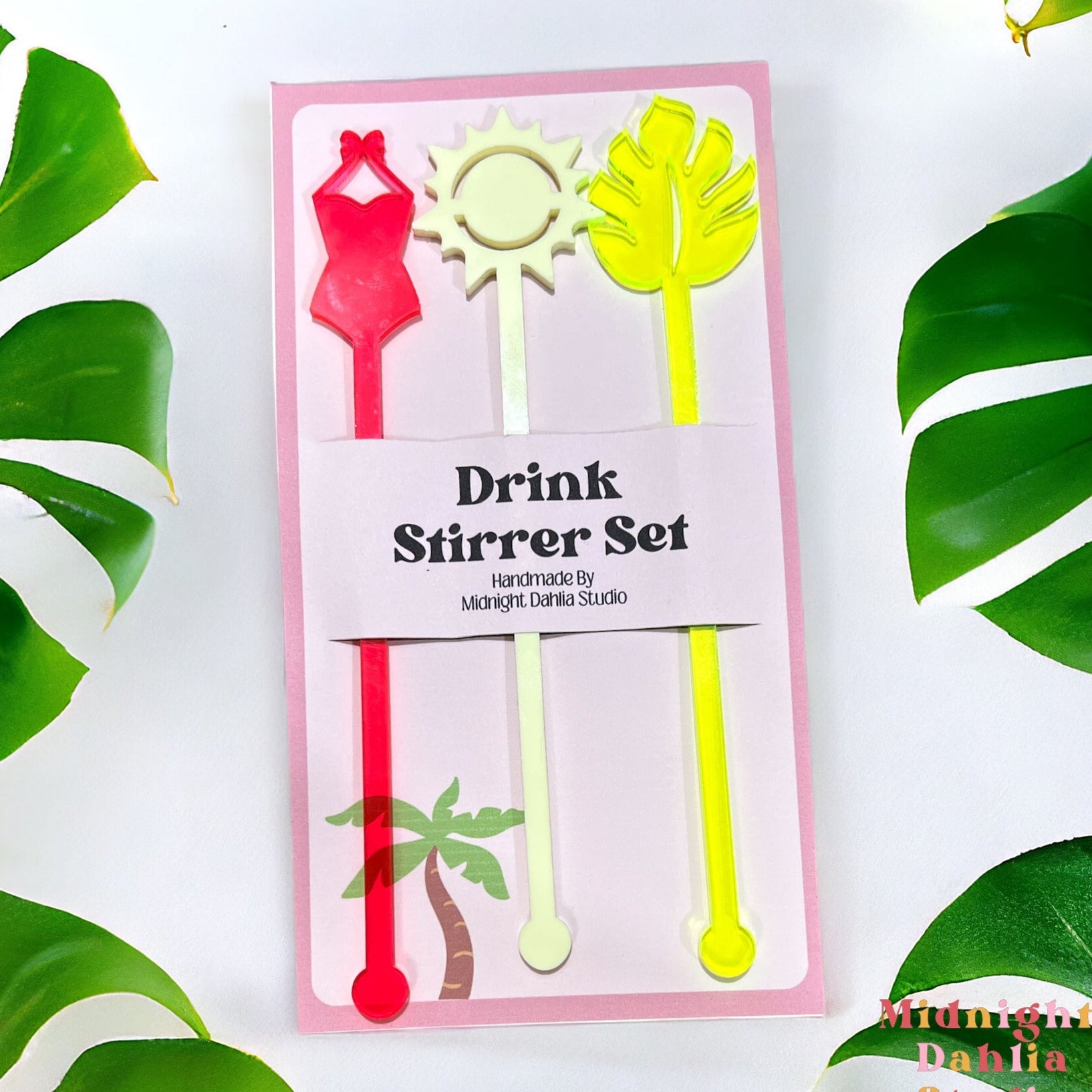 set of three drink stirrers with the top shapes in a swimsuit, sun, and monstera plant tropical leaf in neon pink, light yellow, and neon green.