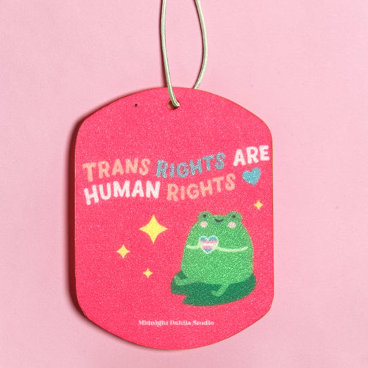 Pink air freshener with a green frog illustration and text on a pink background