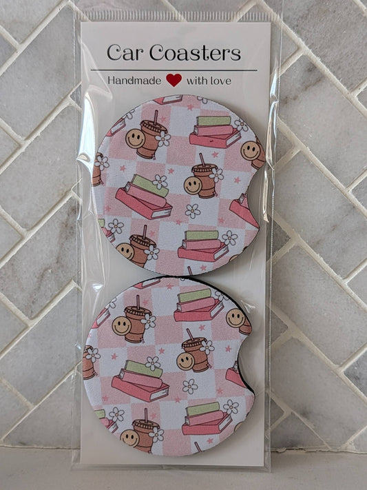 Packaged car coasters with a pink pattern on a tiled surface