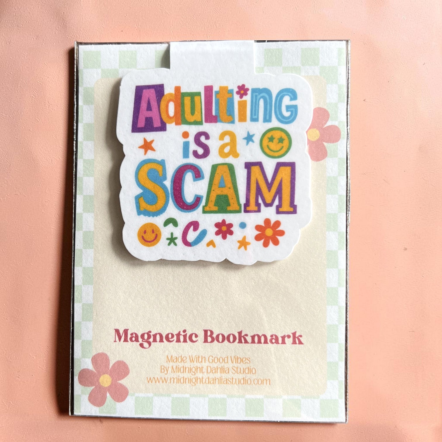 Magnetic bookmark with colorful text 'Adulting is a SCAM' on a checkered background