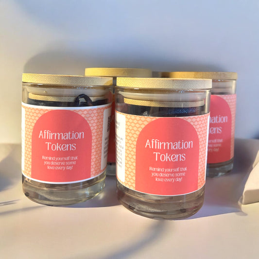 three glass jars with bamboo lids with a sticker that reads affirmation tokens