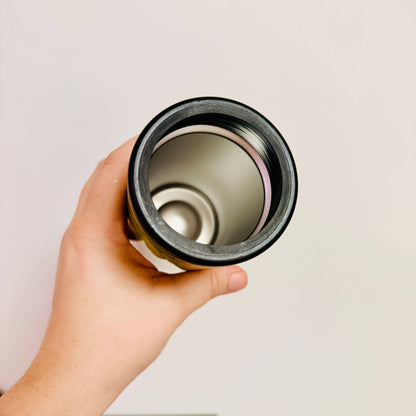 Hand holding a cylindrical object against a plain background
