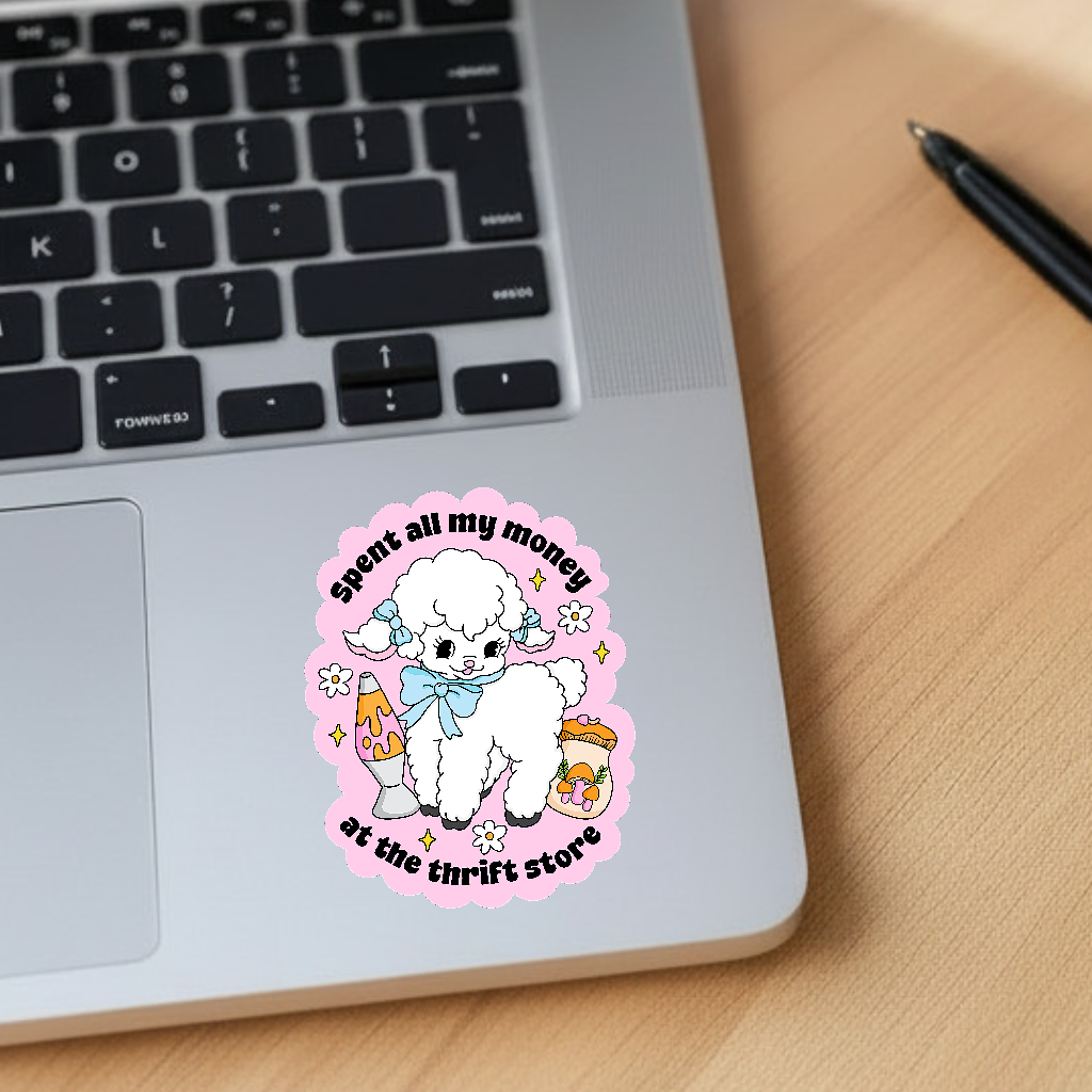 Laptop with a sticker of a white fluffy lamb and text on a wooden surface