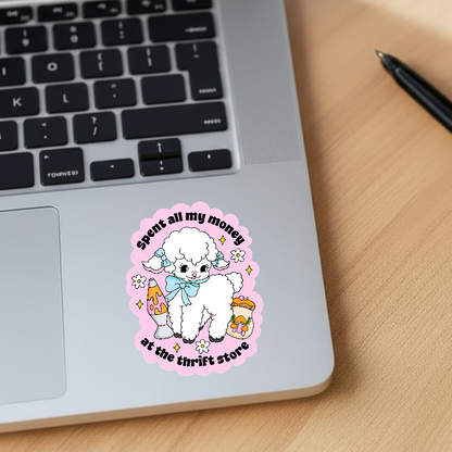 Laptop with a sticker of a white fluffy lamb and text on a wooden surface