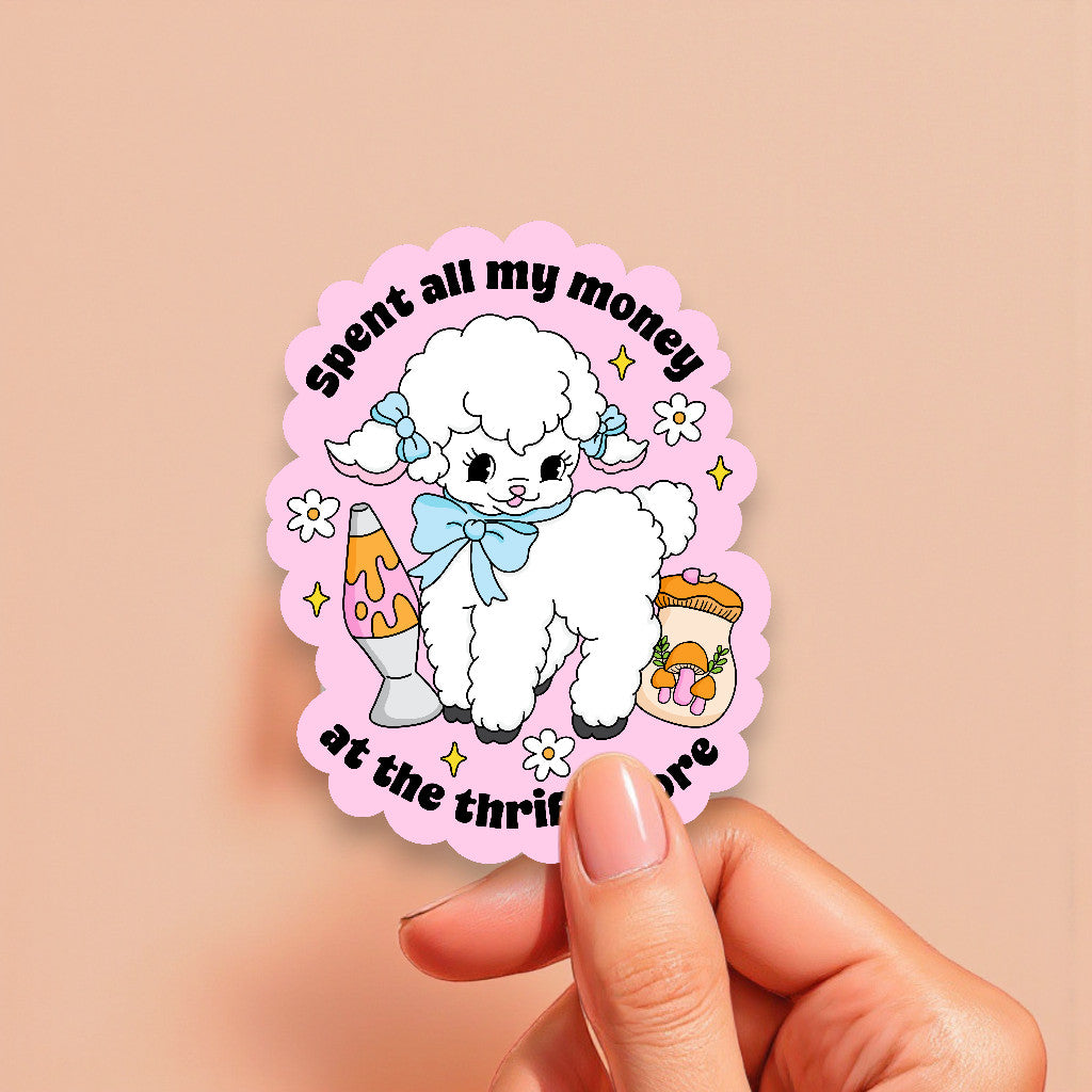 Sticker with a poodle design and text held by a hand on a beige background