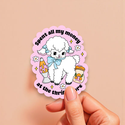 Sticker with a poodle design and text held by a hand on a beige background