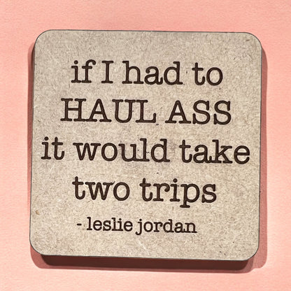A square magnet with a humorous quote printed on it, placed against a pink background.