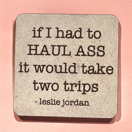 A square magnet with a humorous quote printed on it, placed against a pink background.