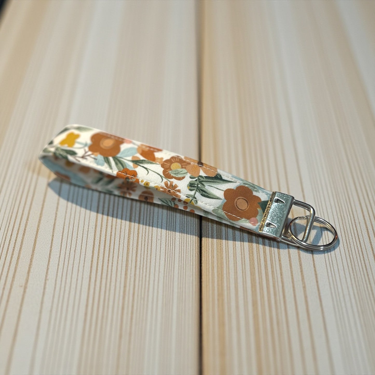 Floral patterned keychain on a wooden surface