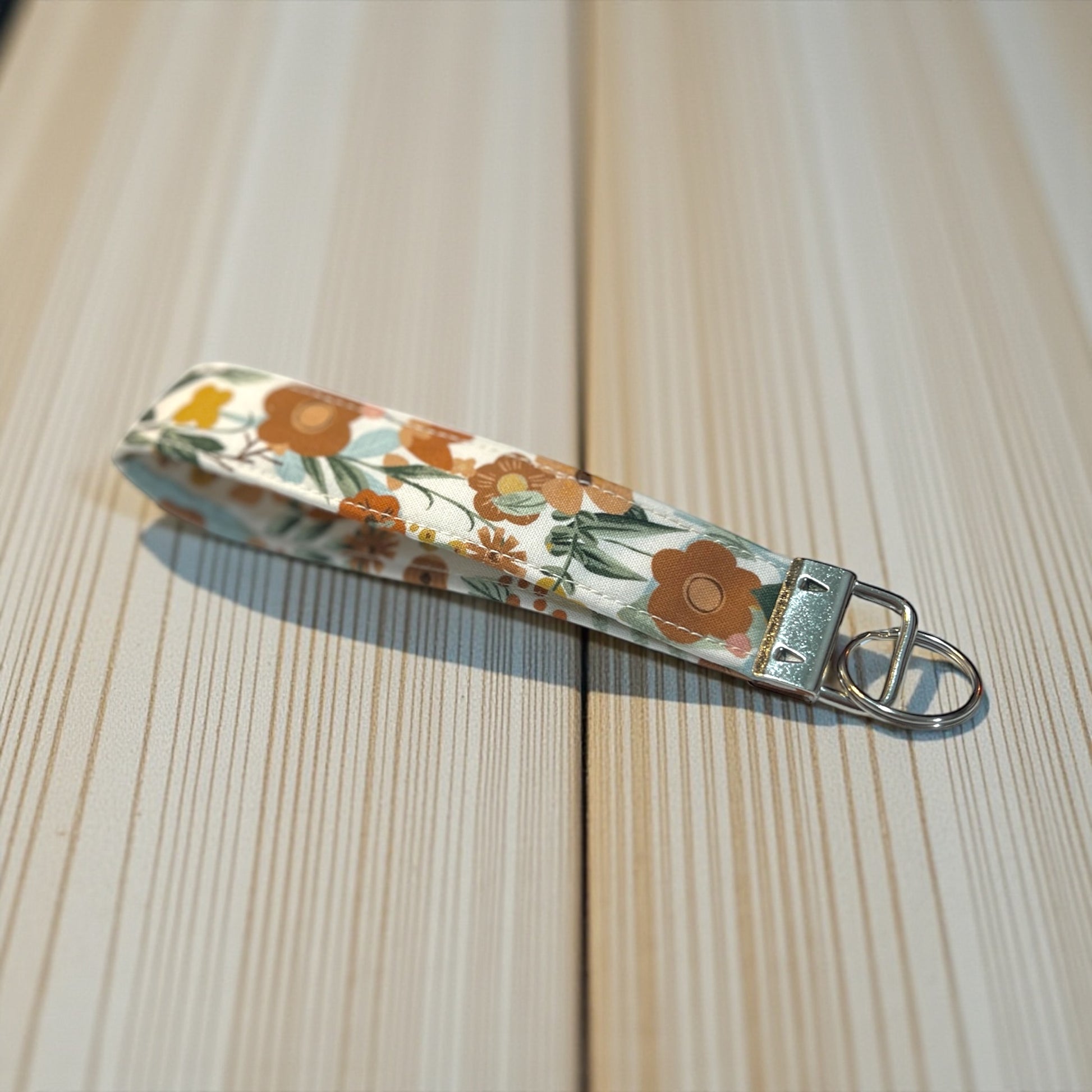Floral patterned keychain on a wooden surface