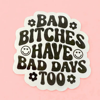 a white sticker with black text that reads bad bitches have bad days too with smiley faces and daisies